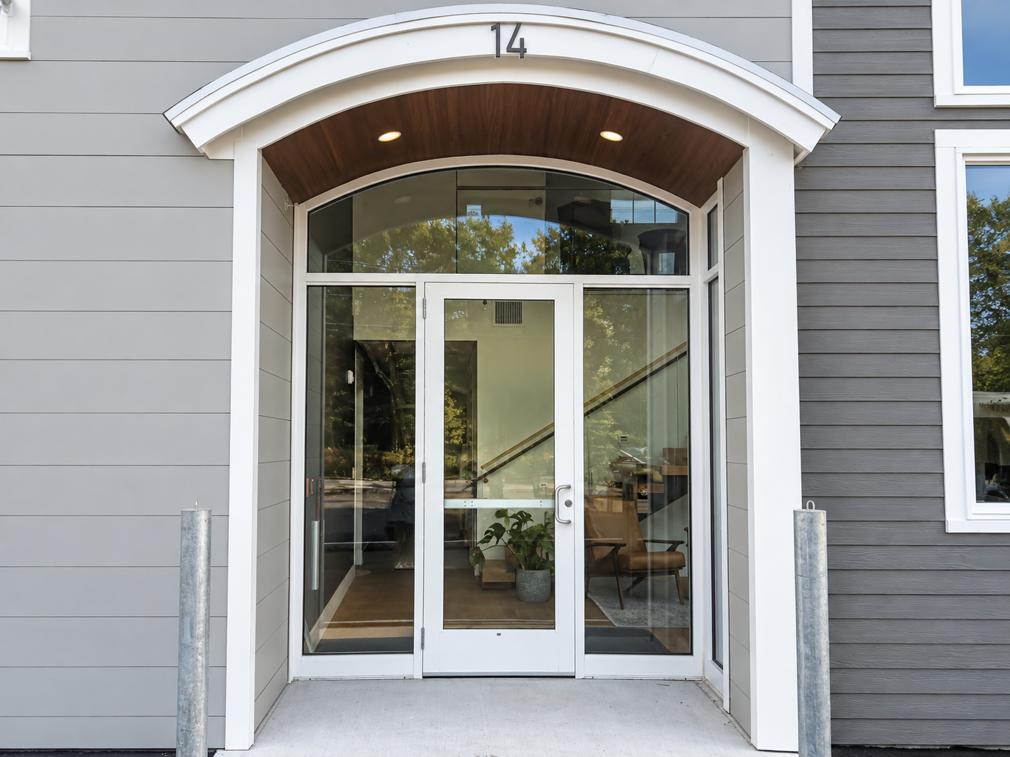 Main glass entrance beneath an arched canopy with the number 14 above the door.